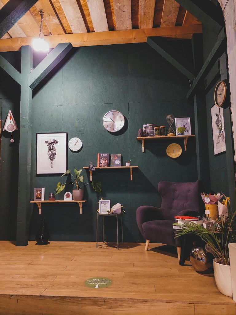 Elegant living room with green walls, wood ceiling, and stylish decor creating a cozy atmosphere.